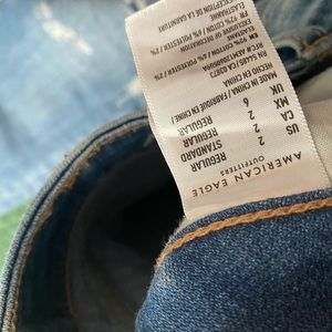 Cropped jeans with patched rips on frontside.